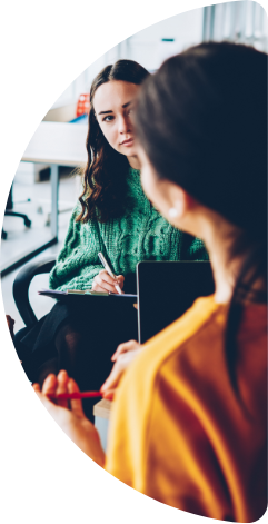 Woman listening to another woman and taking notes