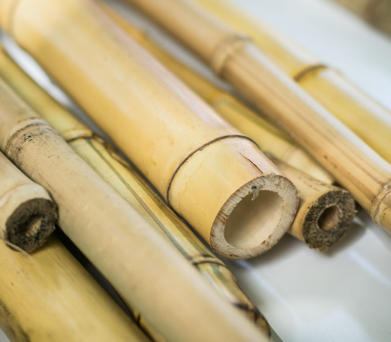 Stacked bamboo sticks arranged neatly on a wooden table, showcasing their natural texture and color.